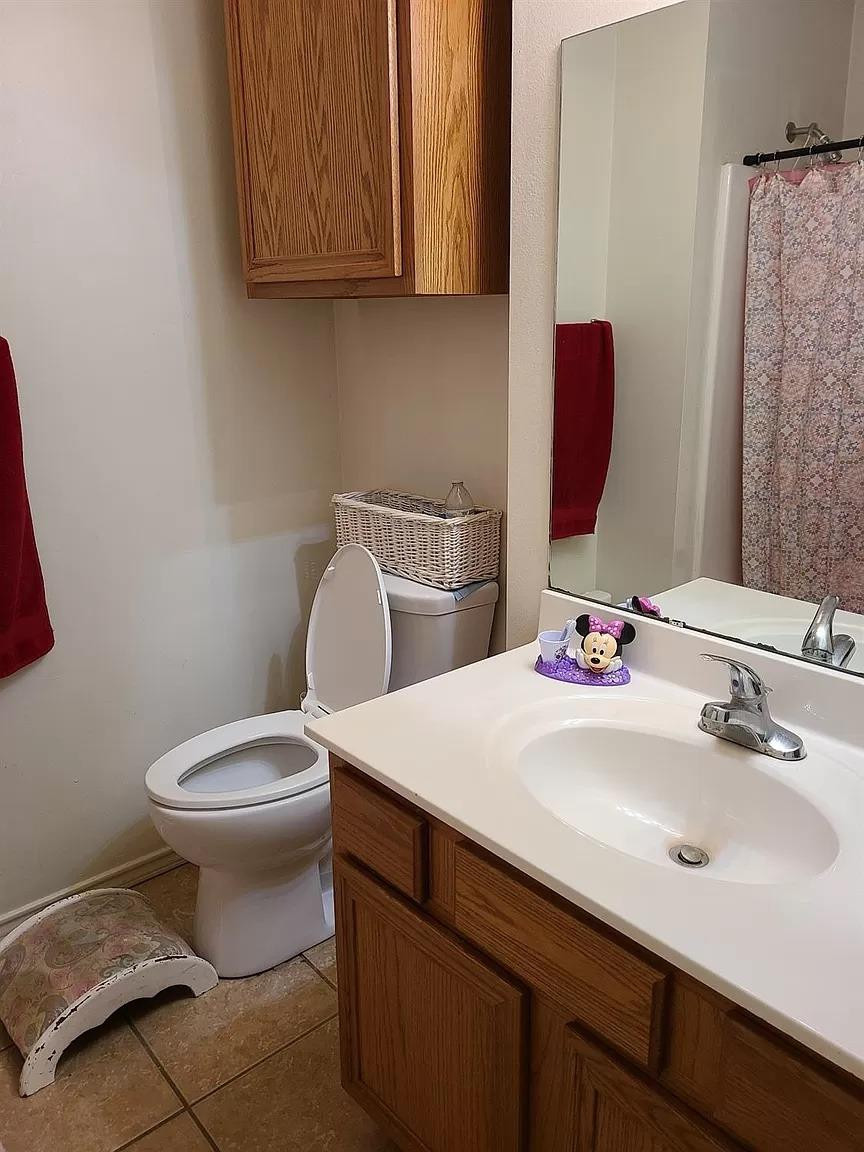 304 North Clinton Avenue, Unit A Lubbock, TX 79416 - Photo 11 of 24 a bathroom with a sink a toilet and mirror