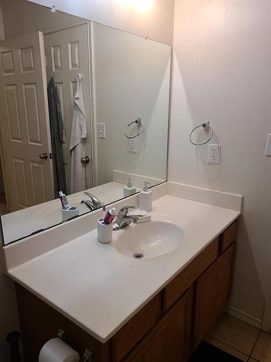 304 North Clinton Avenue, Unit A Lubbock, TX 79416 - Photo 18 of 24 a bathroom with a sink vanity and a mirror
