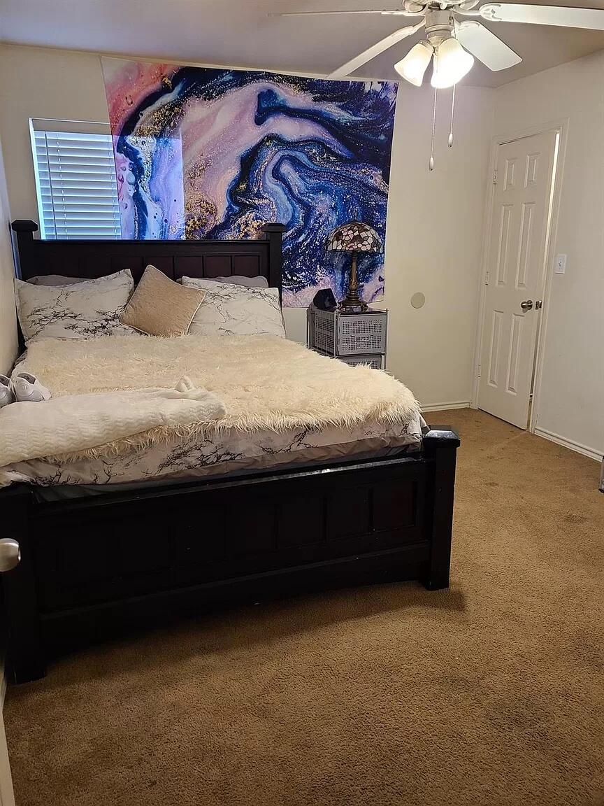 304 North Clinton Avenue, Unit A Lubbock, TX 79416 - Photo 23 of 24 a bed sitting in a bedroom next to a window