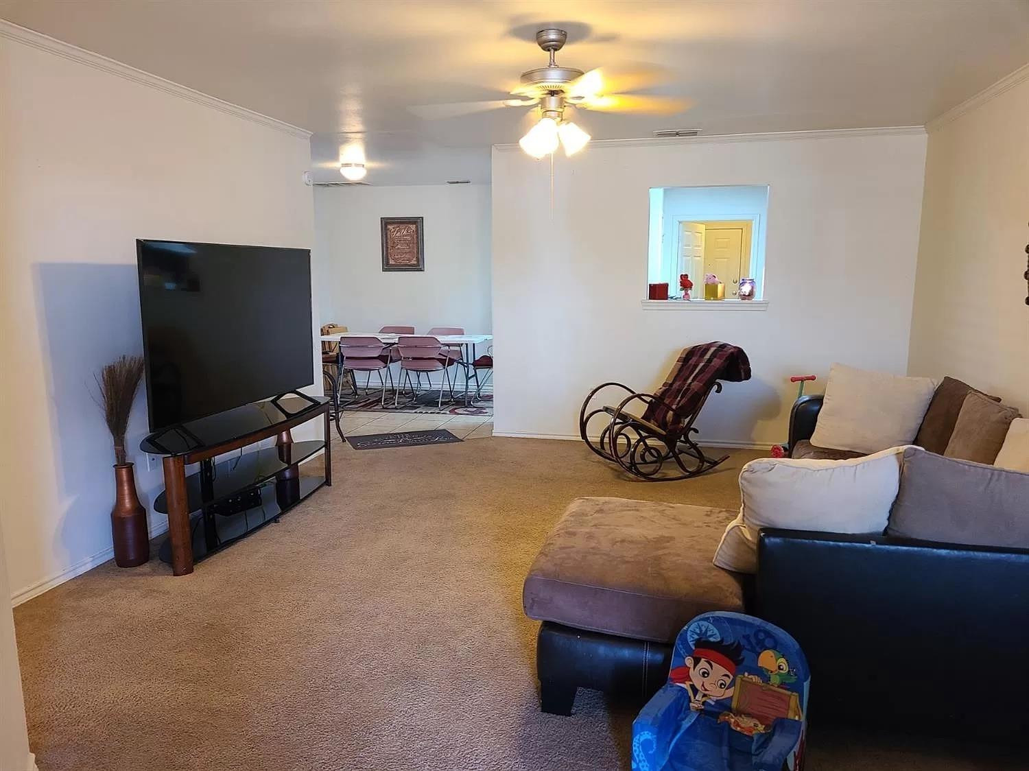 304 North Clinton Avenue, Unit A Lubbock, TX 79416 - Photo 4 of 24 a living room with furniture a window and a flat screen tv