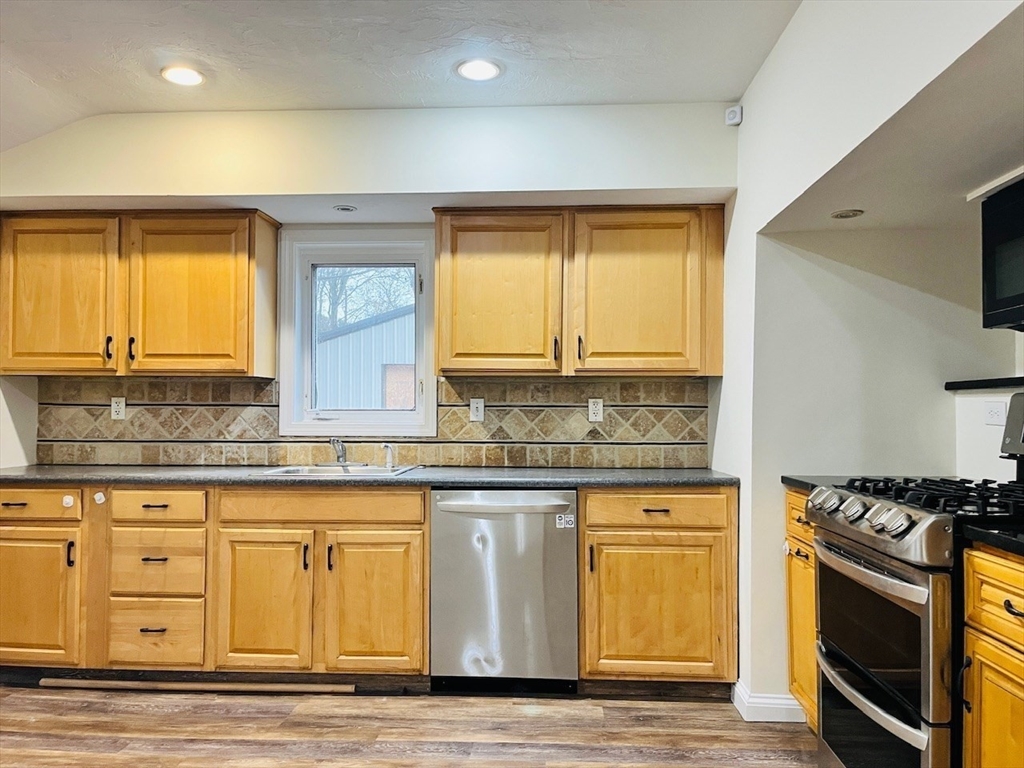 415 Pearl Street Stoughton, MA 02072 - Photo 6 of 24 a kitchen with stainless steel appliances granite countertop a stove and a sink