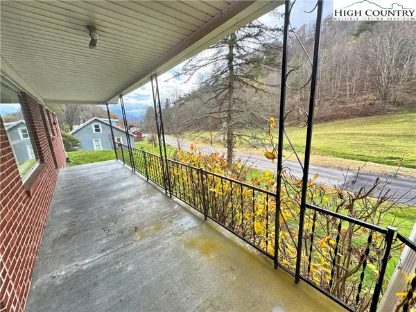 a view of a balcony with floor to ceiling windows and wooden fence
