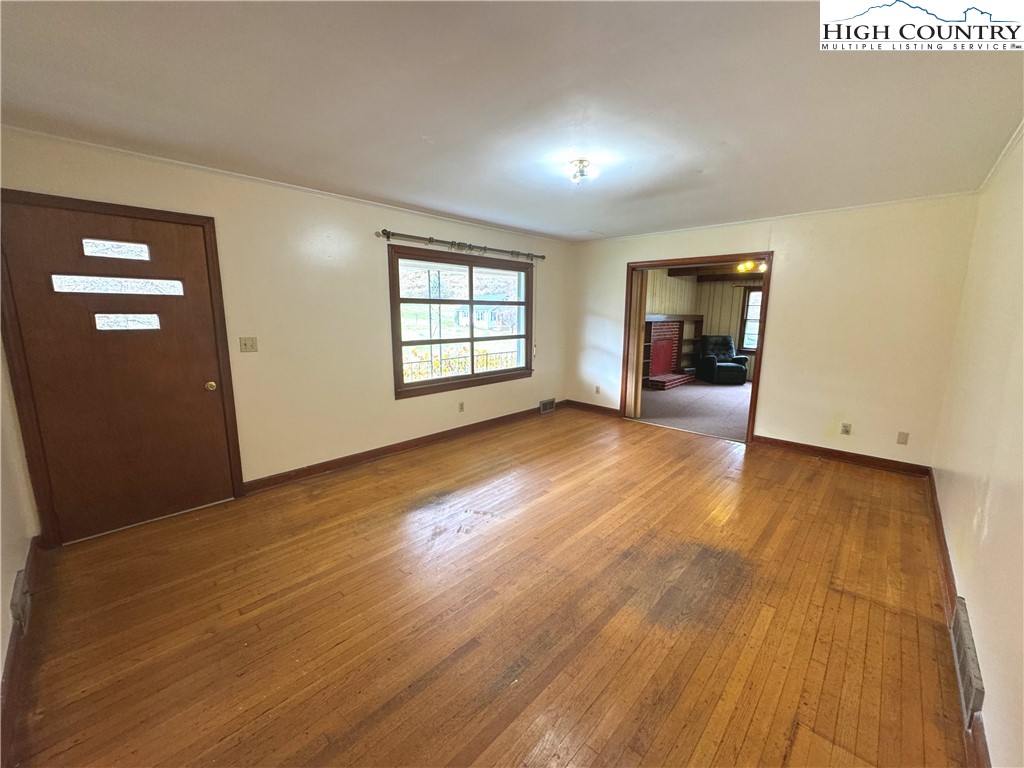 2510 Rich Hill Road Creston, NC 28615 - Photo 5 of 29 an empty room with wooden floor and windows