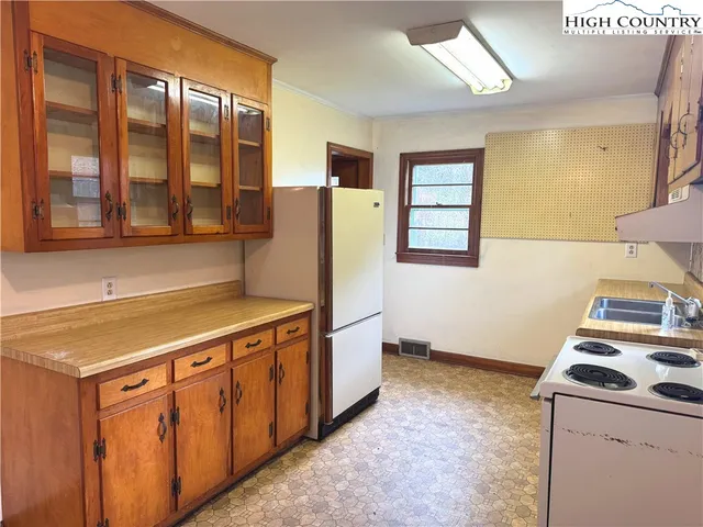 a room with a stove a washer and dryer