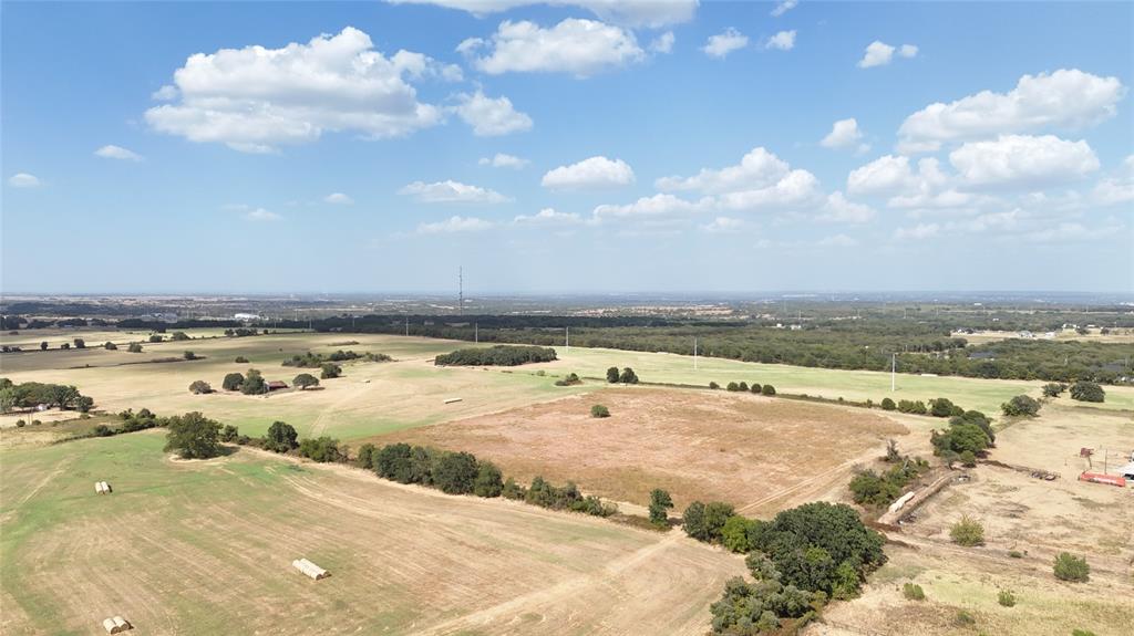 2101 Billings Road Tolar, TX 76476 - Photo 4 of 23 Expansive acreage featuring open fields, scattered mature trees, and a distant urban horizon