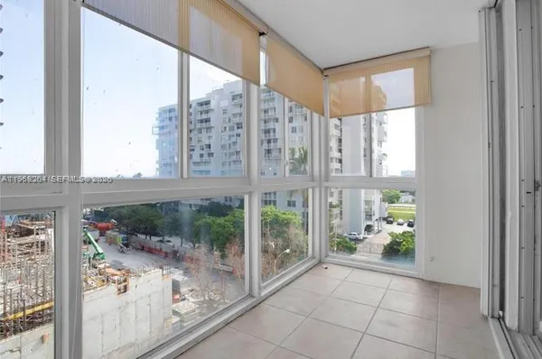 a view of a big room with a floor to ceiling window and an entryway