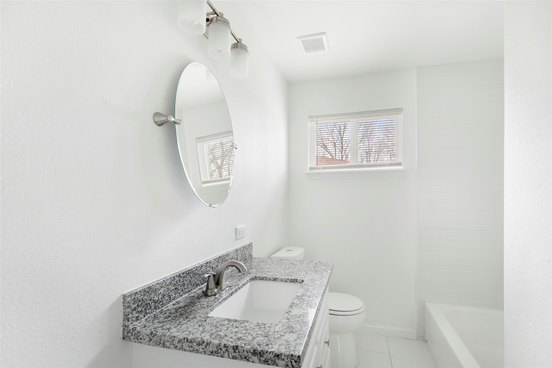 6721 Madrid Street Houston, TX 77021 - Photo 15 of 19 a bathroom with a granite countertop sink a toilet and a mirror