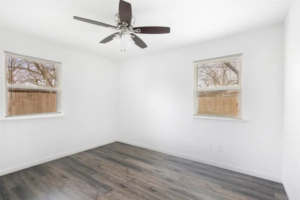 a view of a room with wooden floor and ceiling fan