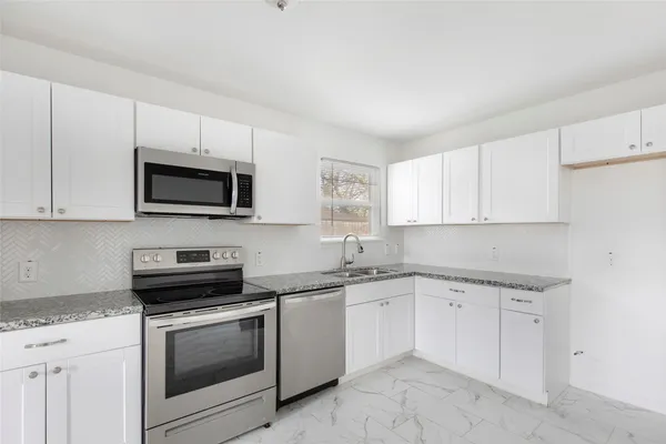 a kitchen with a sink cabinets and appliances