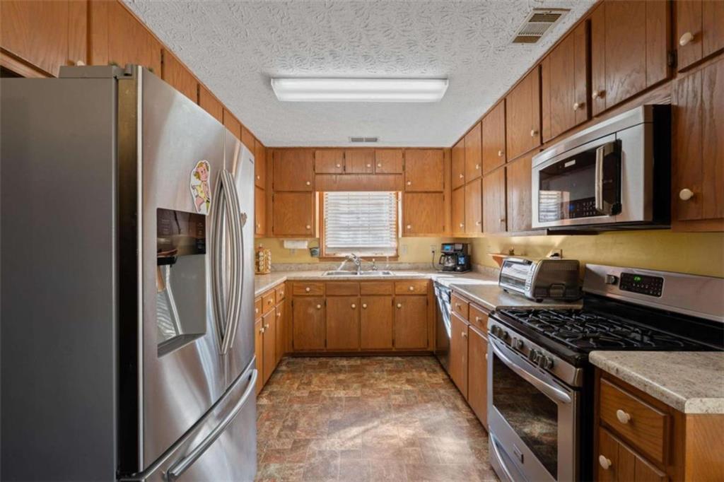 125 Circle Drive Hampton, GA 30228 - Photo 19 of 36 a kitchen with stainless steel appliances granite countertop a stove sink and refrigerator