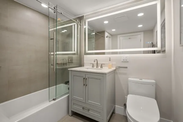 a bathroom with a toilet sink and mirror
