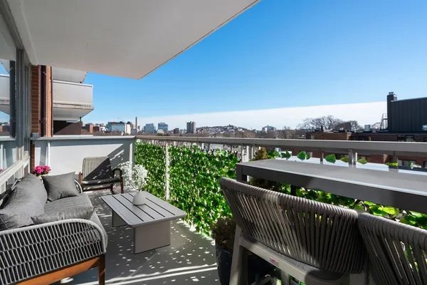 a roof deck with outdoor seating and city view