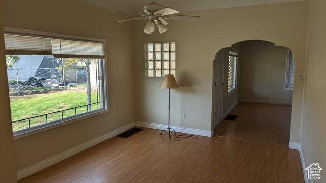 1341 East Crk Road Sandy, UT 84093 - Photo 14 of 24 Spare room featuring wood finished floors, ceiling fan, arched walkways, and baseboards