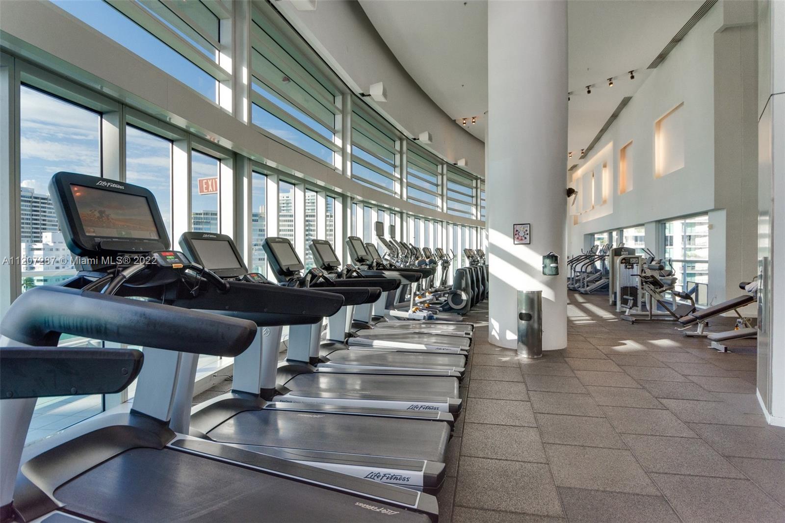 1500 Bay Road, Unit 1414S Miami Beach, FL 33139 - Photo 19 of 23 a view of gym equipment and living room with windows