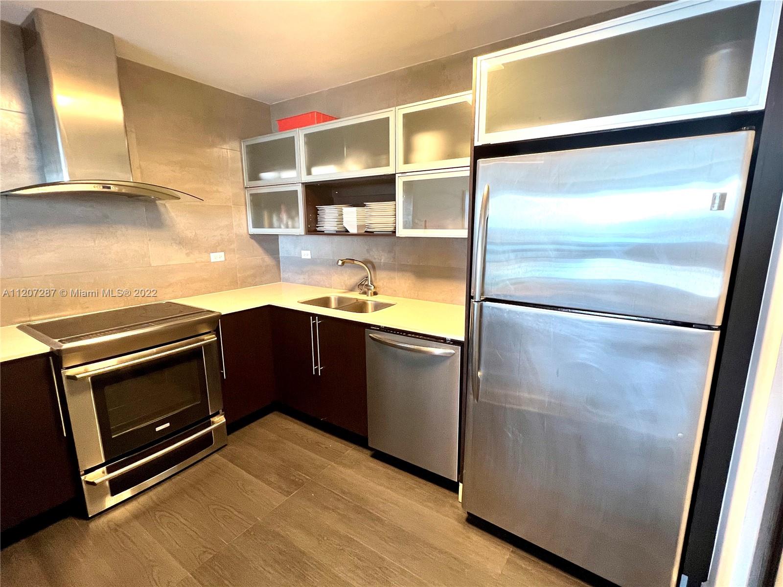 1500 Bay Road, Unit 1414S Miami Beach, FL 33139 - Photo 2 of 23 a kitchen with stainless steel appliances granite countertop a refrigerator a sink and a stove