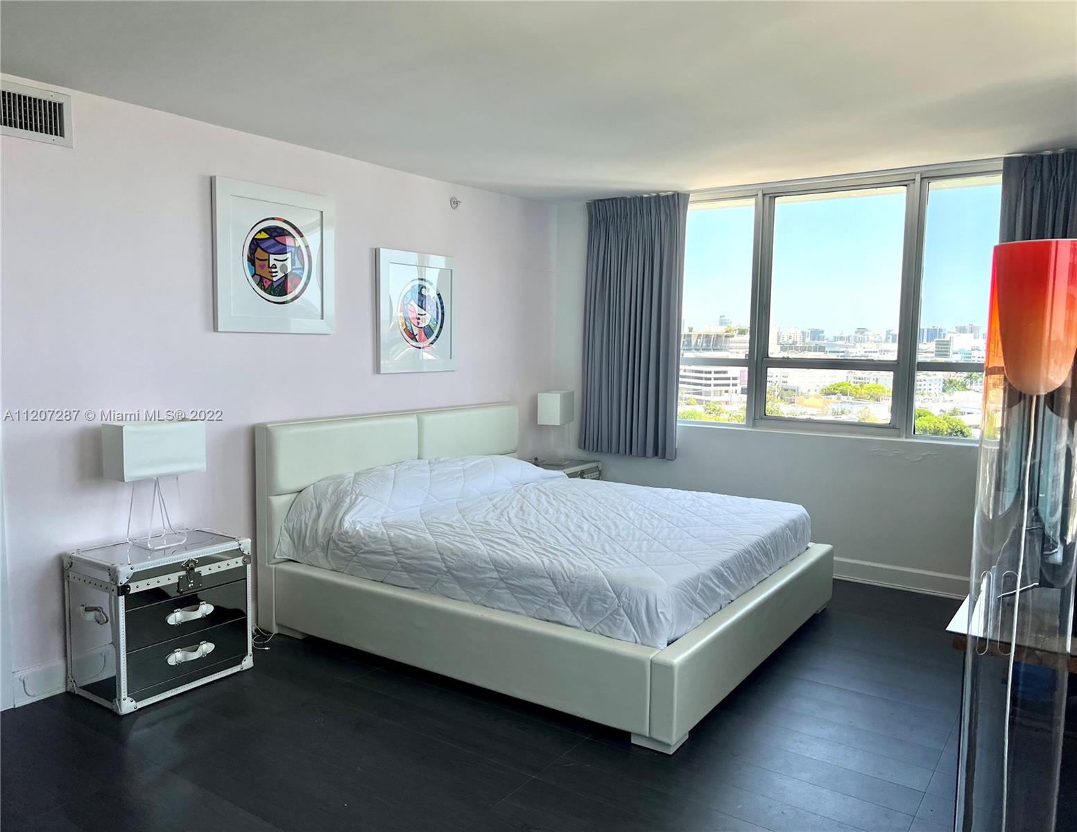 1500 Bay Road, Unit 1414S Miami Beach, FL 33139 - Photo 7 of 23 a bed sitting in a bedroom next to a window