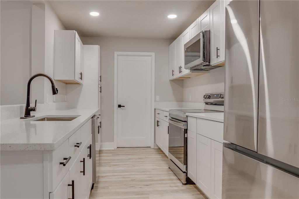 773 Bryant Road Palm Bay, FL 32908 - Photo 5 of 11 a kitchen with stainless steel appliances granite countertop a refrigerator and a sink