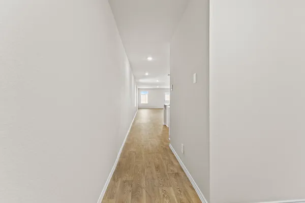 a view of a hallway with wooden floor