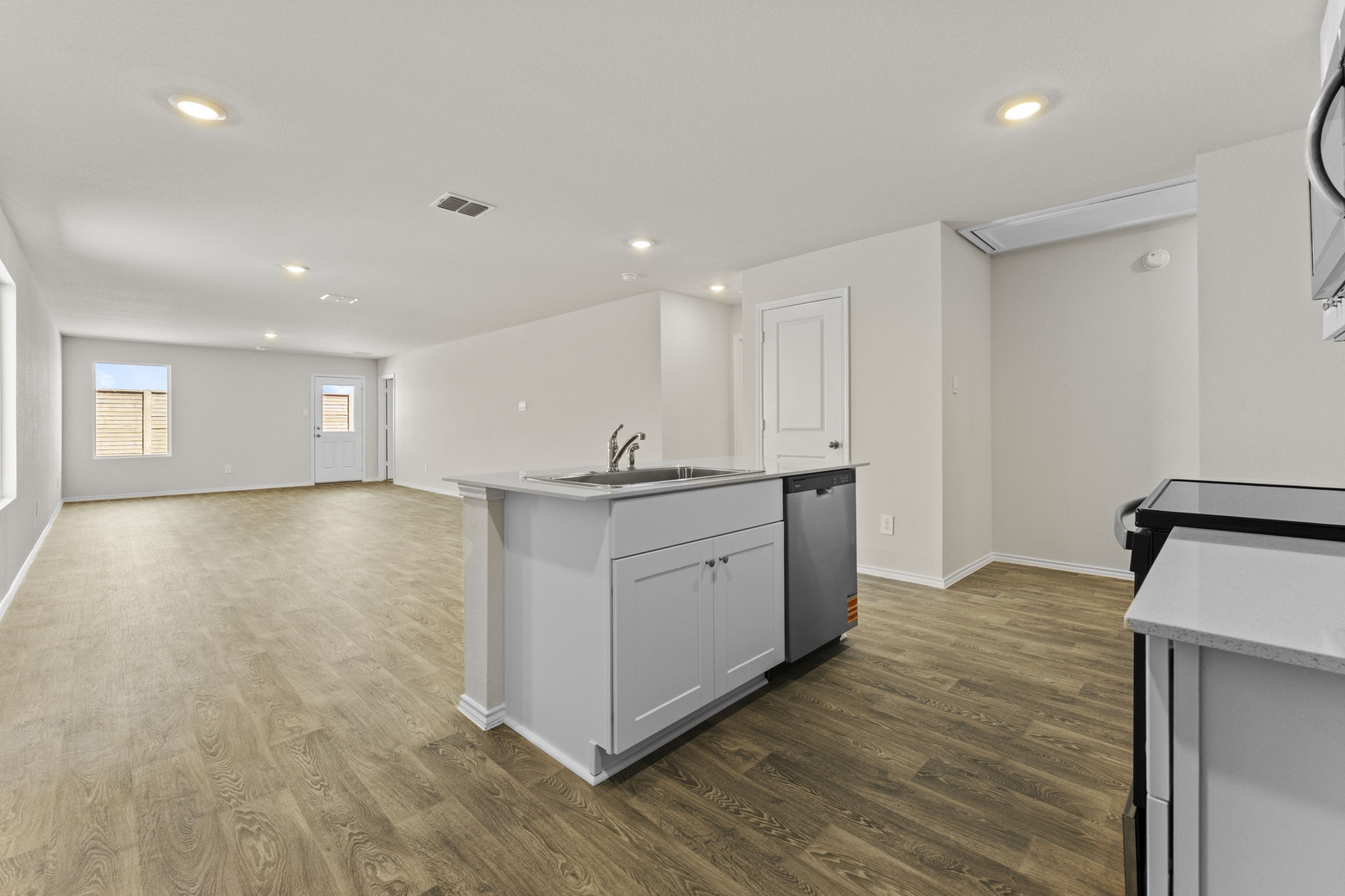 401 Wild Goose Drive Luling, TX 78648 - Photo 4 of 26 a kitchen with stainless steel appliances granite countertop a white cabinets and wooden floor