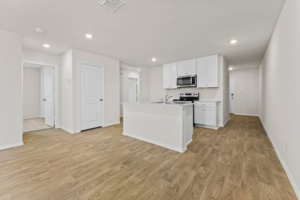 a kitchen with stainless steel appliances granite countertop a stove a sink and a refrigerator