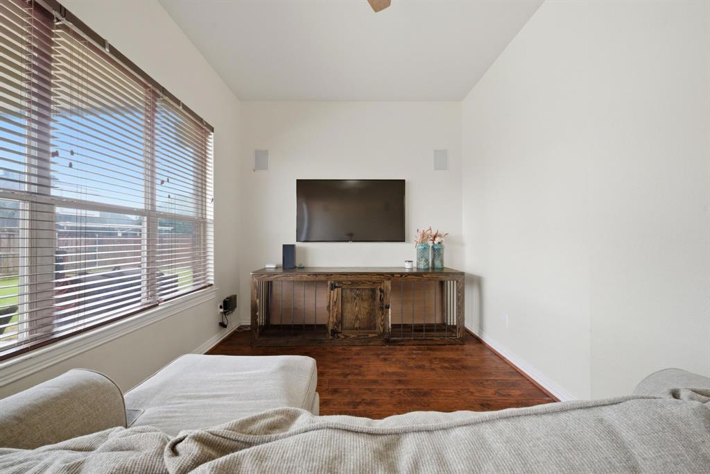 603 Cedar Drive Pilot Point, TX 76258 - Photo 22 of 39 Living area featuring wood-finish flooring, white walls, and a large window with blinds