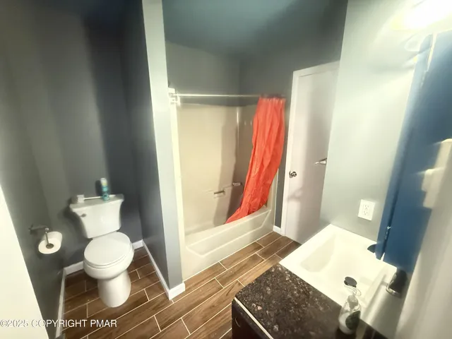 a bathroom with a toilet and a shower