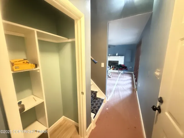 a view of a hallway view with wooden floor and living room