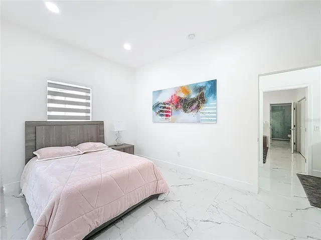 a bedroom with a bed and a painting on the wall