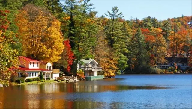 a view of swimming pool with outdoor seating and trees in the background