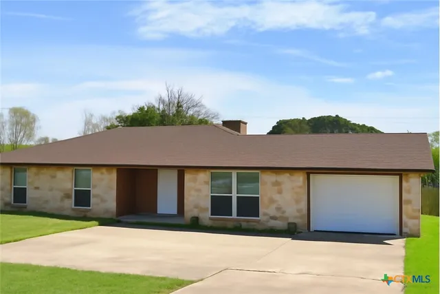 a front view of a house with a garden and yard