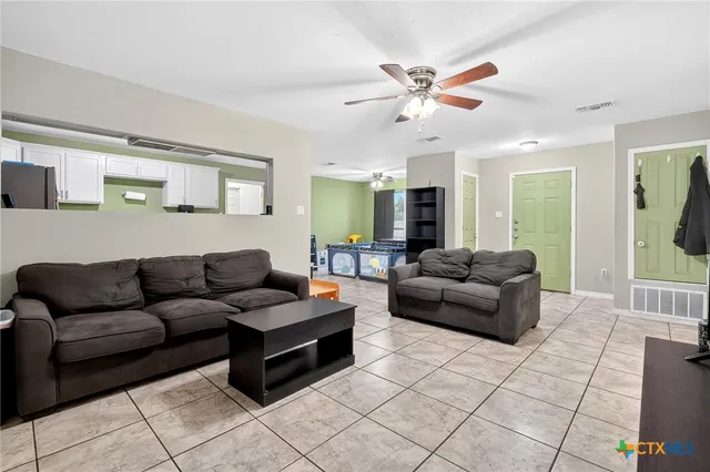 a living room with furniture and a ceiling fan