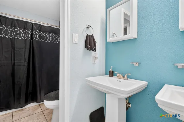 a bathroom with a sink a toilet and a mirror