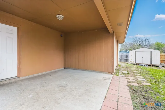 a view of an empty room with a sink and a window