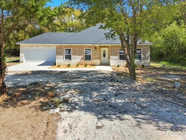 a view of a house with backyard and a tree