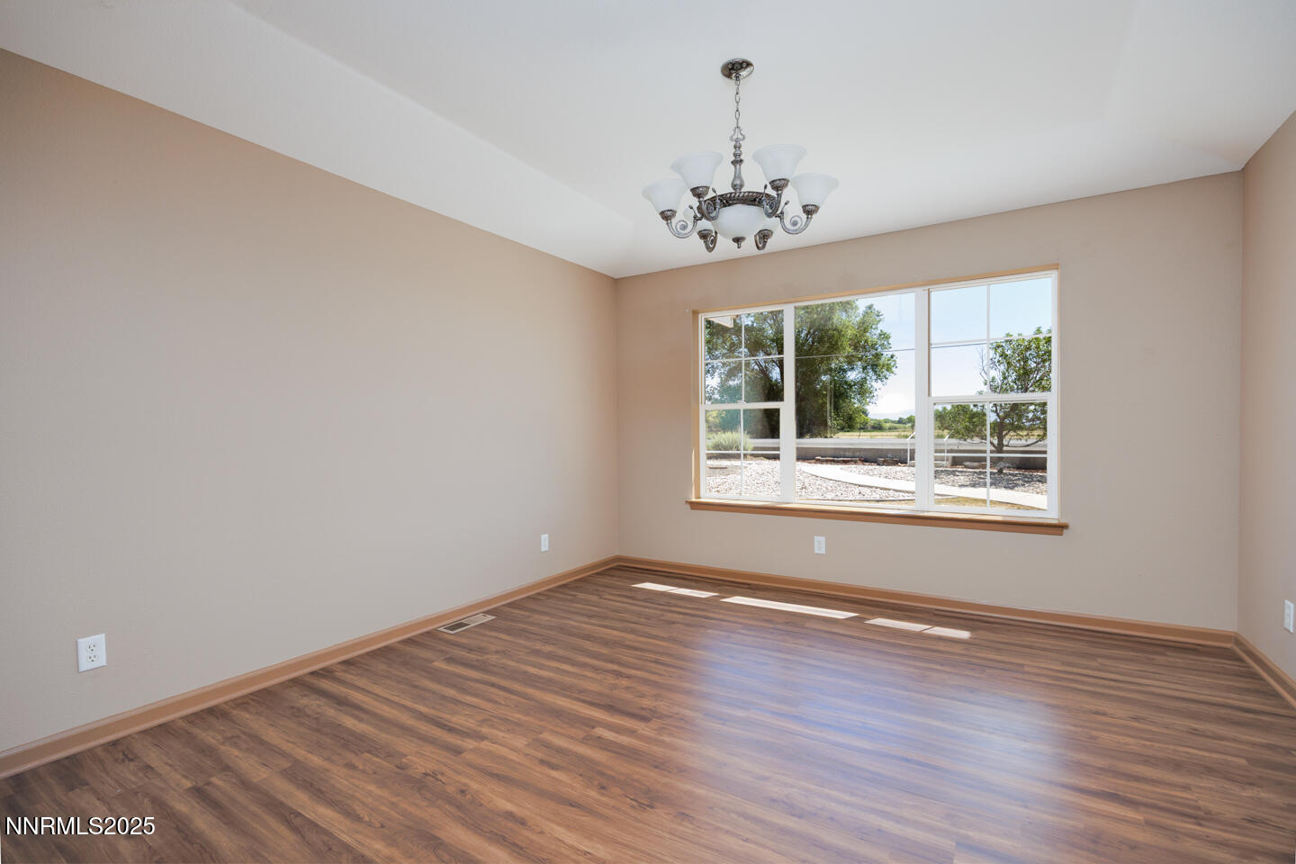 305 Cemetery Road Fallon, NV 89406 - Photo 8 of 26 a view of an empty room with wooden floor and a window