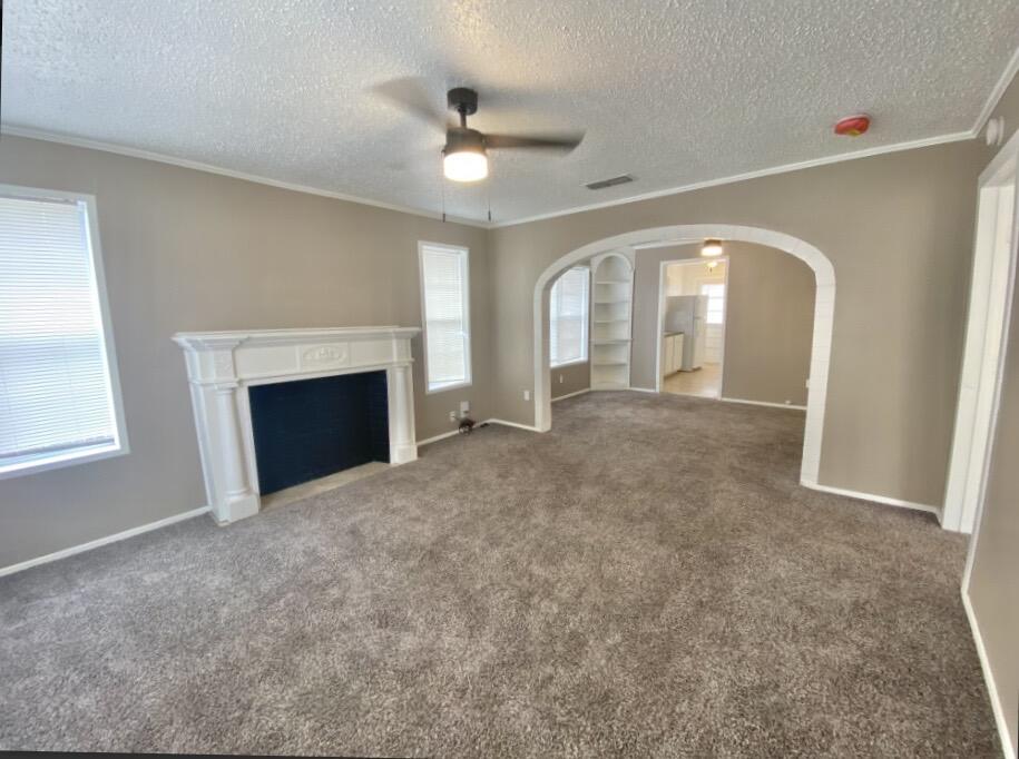 2114 27th Street Lubbock, TX 79411 - Photo 2 of 9 an empty room with windows and fireplace