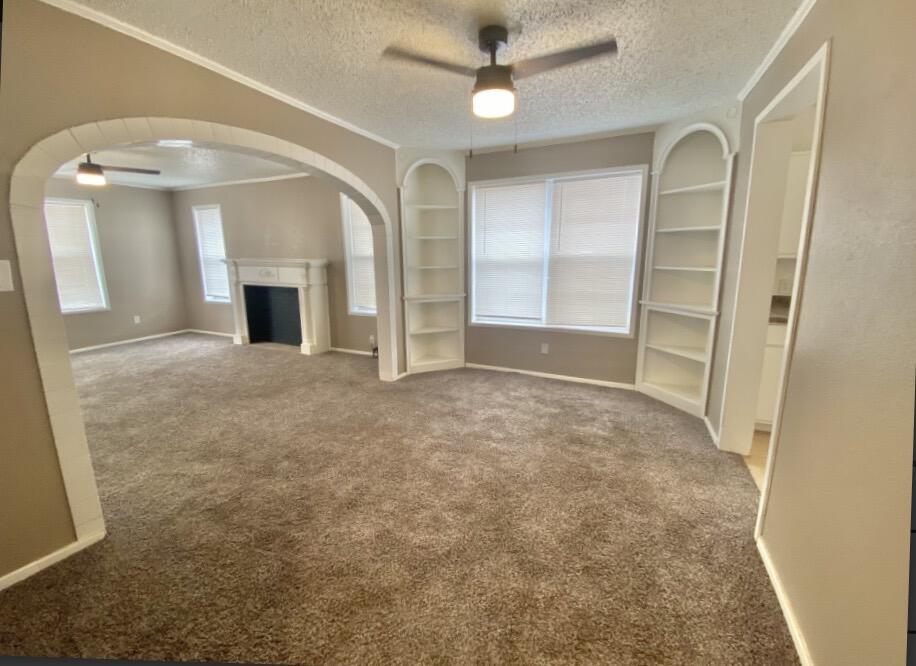 2114 27th Street Lubbock, TX 79411 - Photo 3 of 9 wooden floor in an empty room with a fireplace