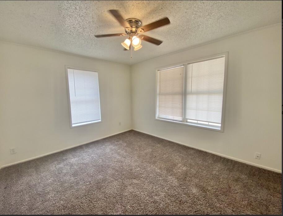 2114 27th Street Lubbock, TX 79411 - Photo 7 of 9 an empty room with windows and ceiling fan view
