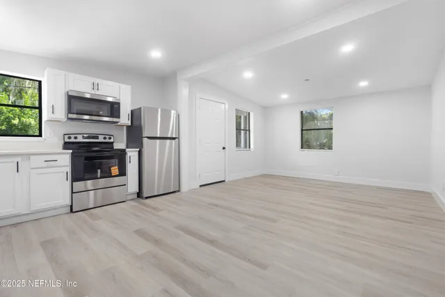 a view of kitchen with granite countertop stainless steel appliances cabinets and a window