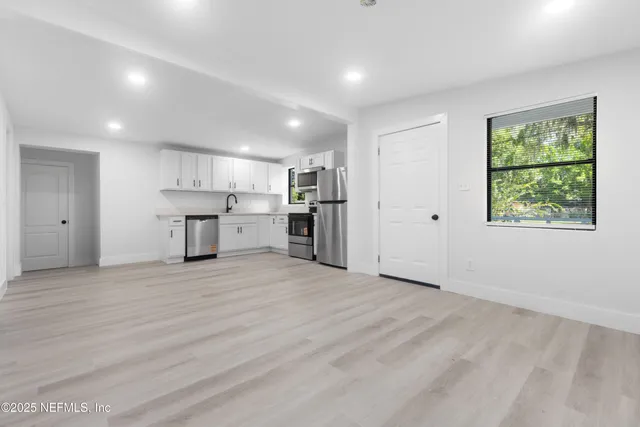 a view of a kitchen with a sink and a refrigerator