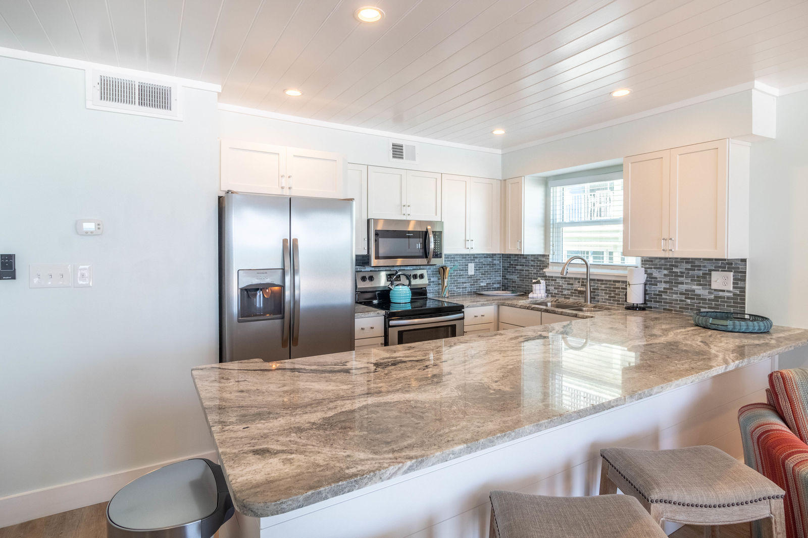 595 Eastern Lake Road, Unit 206 Santa Rosa Beach, FL 32459 - Photo 11 of 33 a kitchen with granite countertop a refrigerator a sink a stove a dining table and chairs