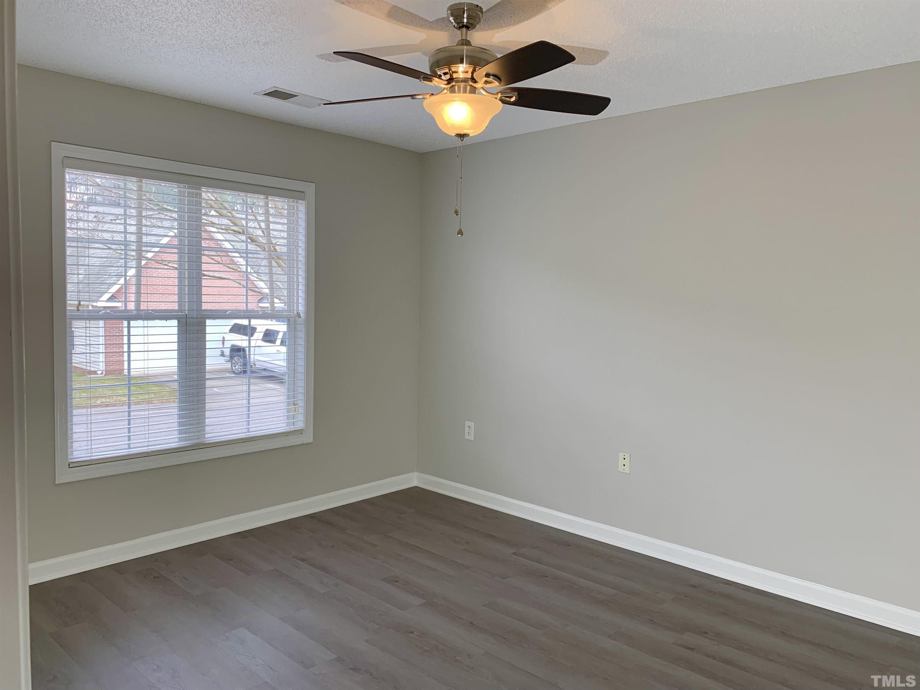 11320 Clubhaven Place, Unit 102 Raleigh, NC 27617 - Photo 2 of 15 a view of an empty room with window and chandelier fan