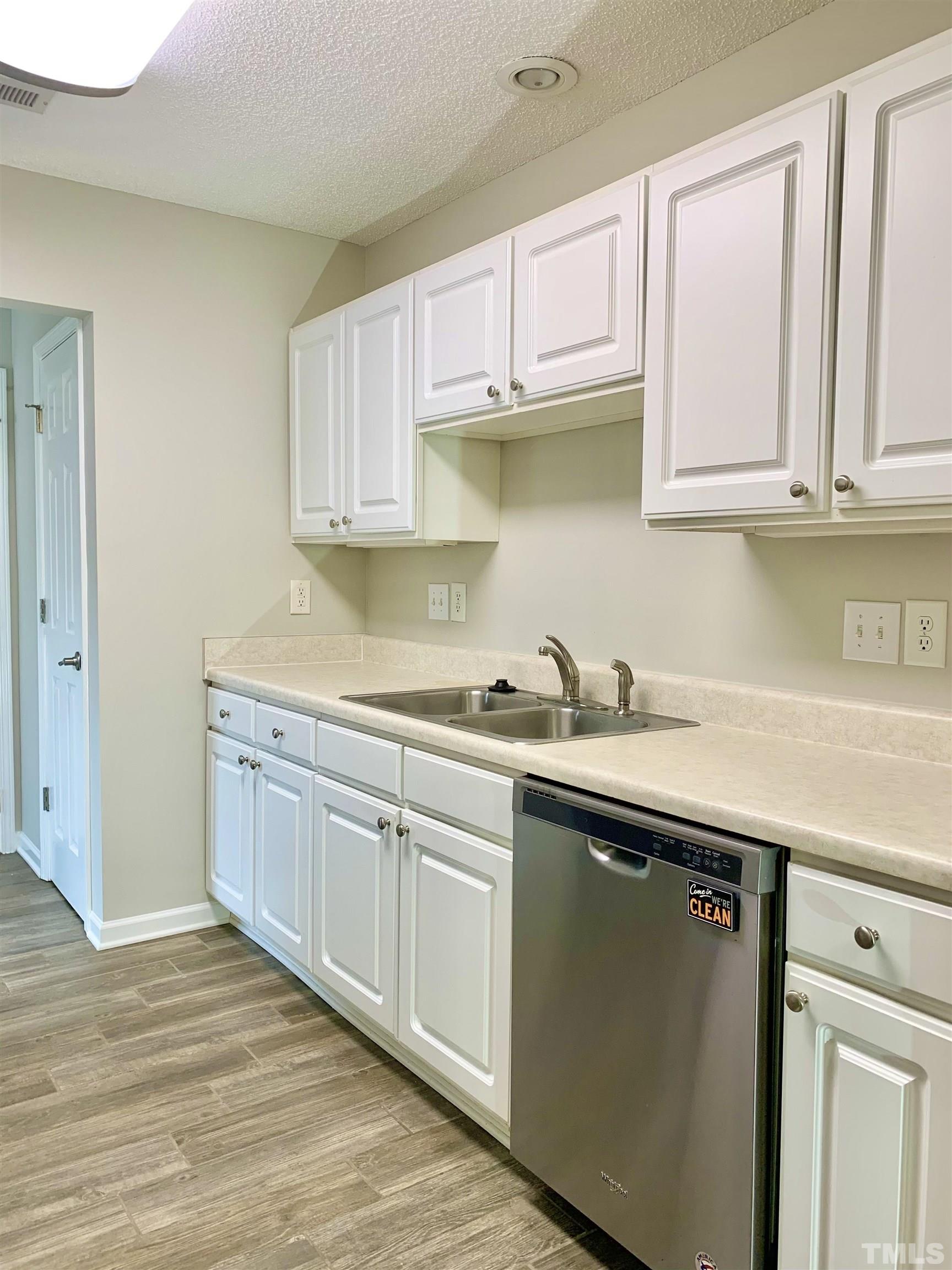 11320 Clubhaven Place, Unit 102 Raleigh, NC 27617 - Photo 10 of 15 a kitchen with stainless steel appliances granite countertop a sink and cabinets with wooden floor