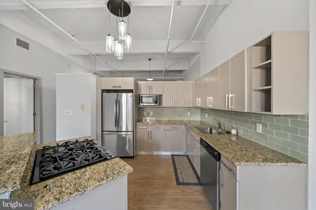 a kitchen with stainless steel appliances granite countertop a sink stove and refrigerator