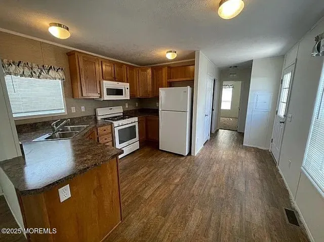 a kitchen with stainless steel appliances granite countertop a refrigerator a stove top oven a sink and dishwasher