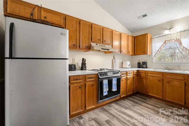 a kitchen with stainless steel appliances granite countertop a refrigerator a stove a sink and a microwave