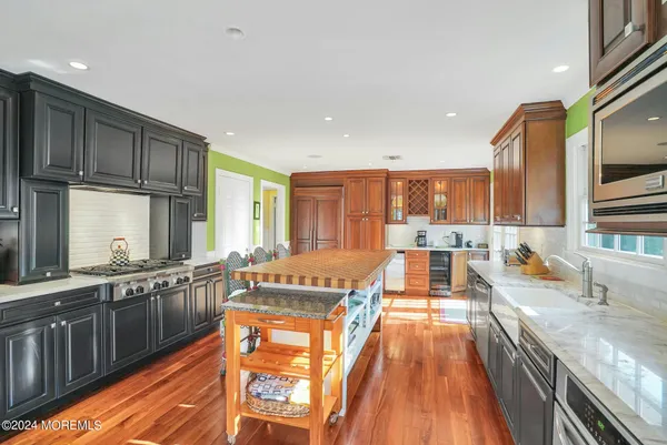 a large kitchen with stainless steel appliances granite countertop a stove a sink and a microwave