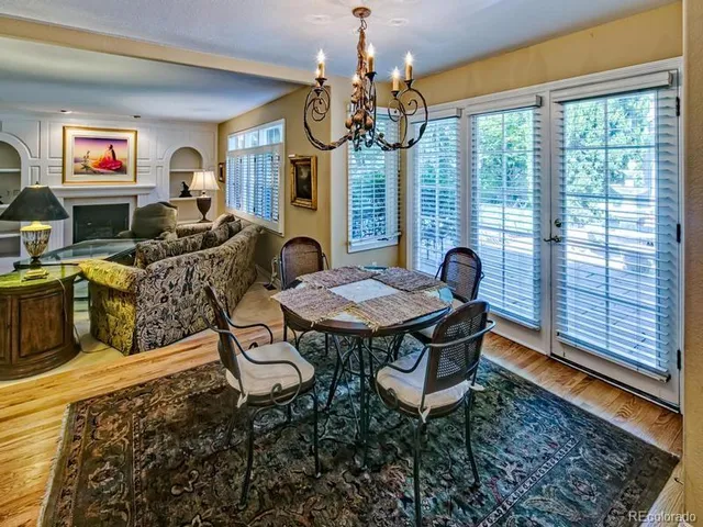 a view of a dining room with furniture a chandelier and wooden floor