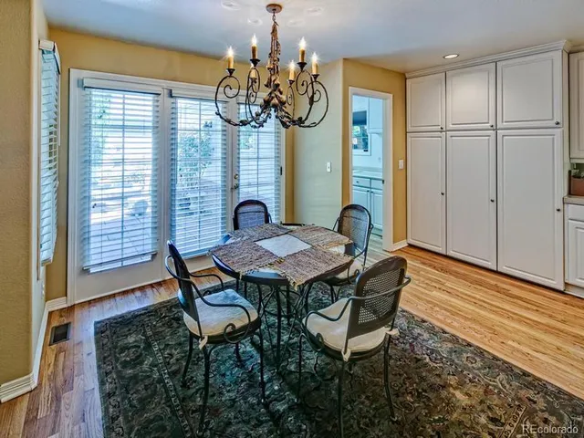 a view of a dining room with furniture a chandelier and wooden floor