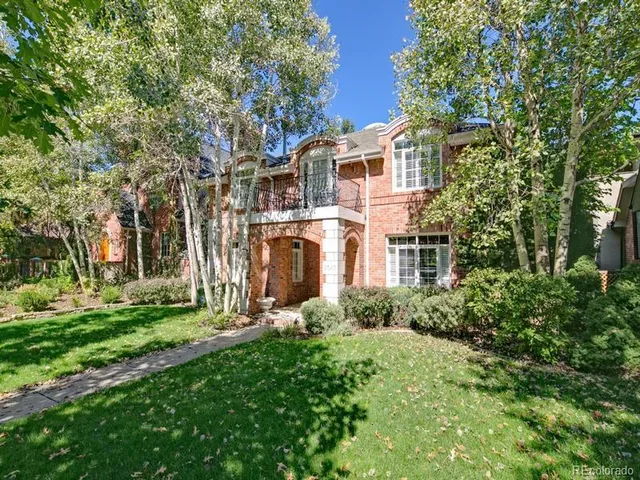 a view of a big yard with plants and large trees